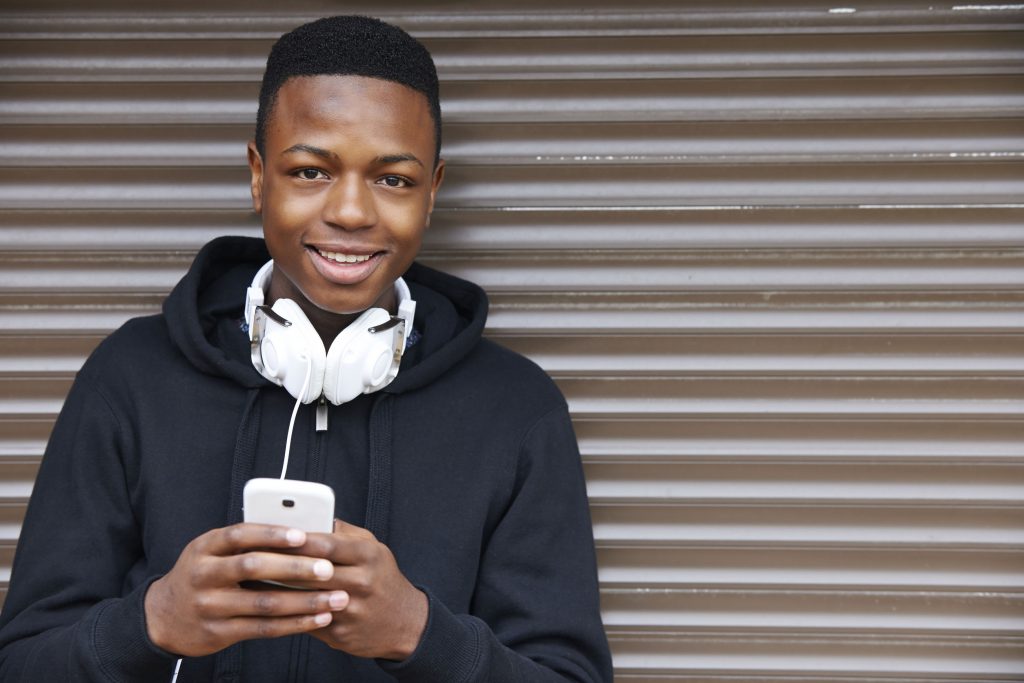 Smiling young man with headphones and smartphone